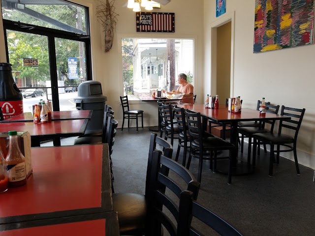 Inside the Guy's Po-Boys dining room with red tables